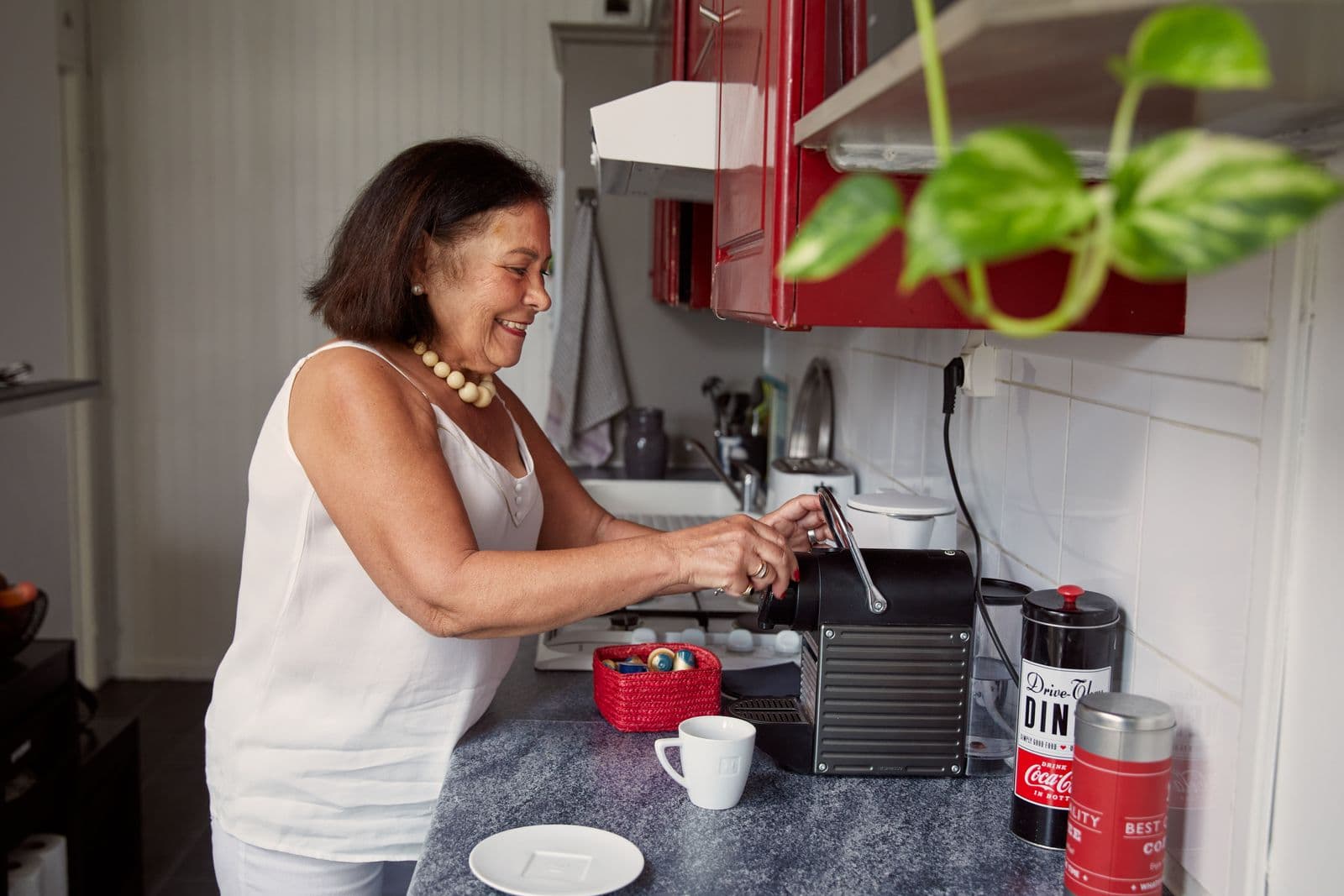 Femme d'une soixantaine d'années qui fait un café