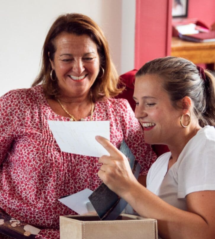 Une jeune et une seniors regardent des photos en souriant